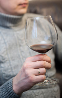 Midsection of woman holding wineglass