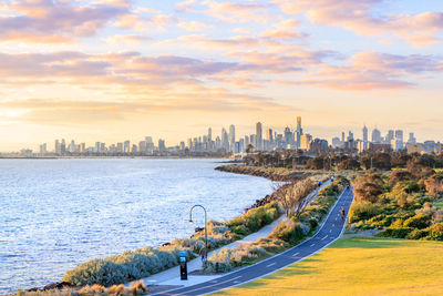 Panoramic view of sea and buildings against sky during sunset
