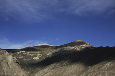 Scenic view of mountains against blue sky