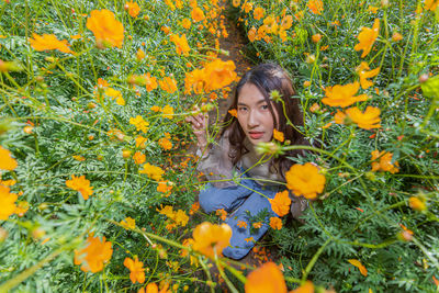 Portrait of woman against yellow flowering plants