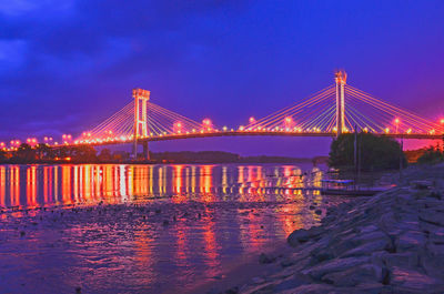 Illuminated suspension bridge over river