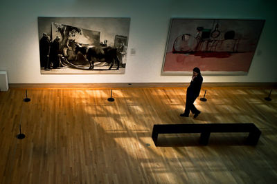 Man and woman standing on wall in museum