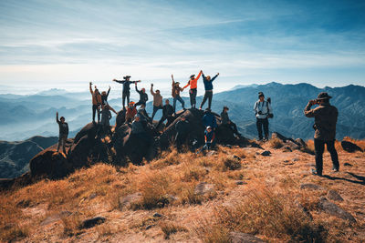 Group of people standing on land against sky