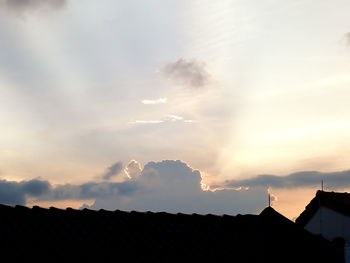 Silhouette houses against sky during sunset