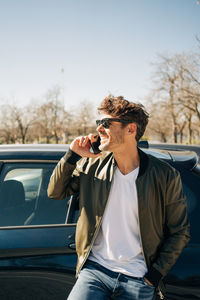 Full length of young man driving car against sky