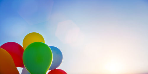 Low angle view of colorful balloons against sky