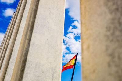 Low angle view of flags against cloudy sky