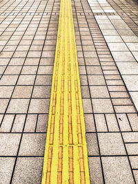 High angle view of yellow lines on footpath
