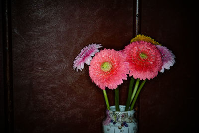 Close-up of pink flower vase against wall