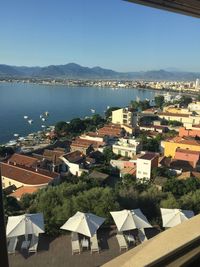 High angle view of townscape by sea against clear sky