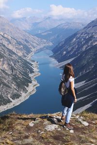 Rear view of woman looking at mountains against sky