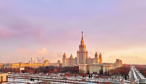 Buildings in city against sky during sunset