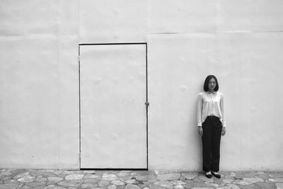 Portrait of woman standing against wall