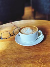 Coffee cup with eyeglasses on table
