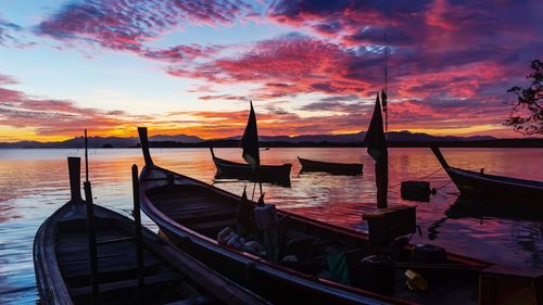 Boats moored in sea during sunset