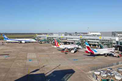 Airplane on airport runway against clear blue sky