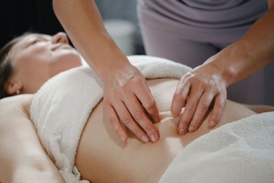 Top view of hands massaging female abdomen. therapist applying pressure on belly. woman receiving