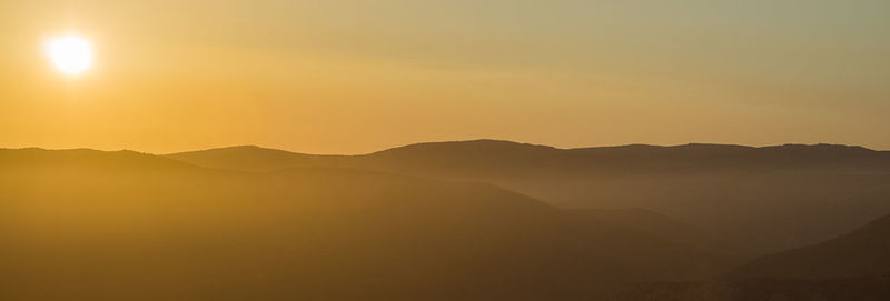 Scenic view of silhouette mountains against sky during sunset