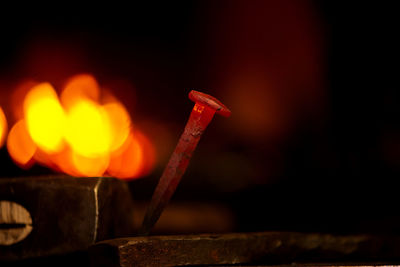 Close-up hot metal nail on an anvil in blacksmith's workshop