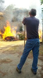 Rear view of man on road against trees