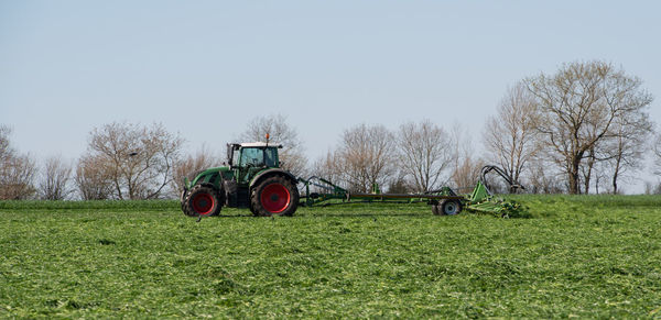 Tractor on field against clear sky