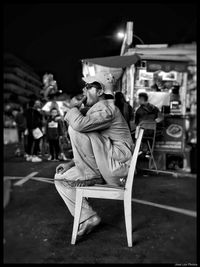 Men sitting on chair at night