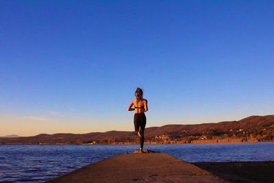 Woman exercising by sea