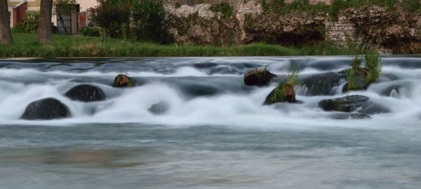 Scenic view of waterfall against trees