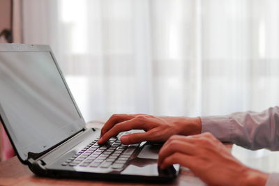 Midsection of man using laptop on table