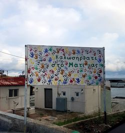 Graffiti on building against cloudy sky