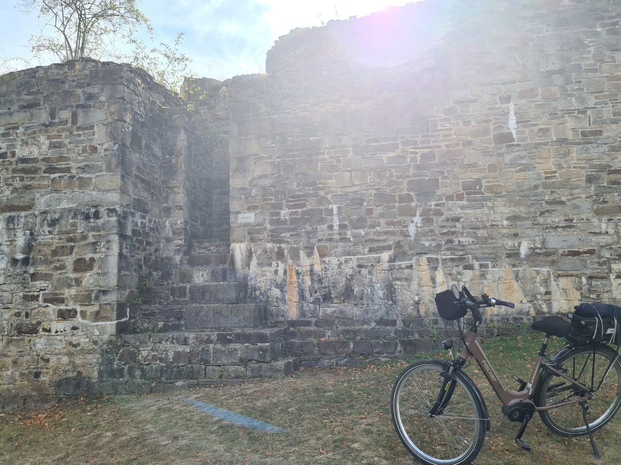 transportation, bicycle, architecture, built structure, nature, travel, sunlight, mode of transportation, sky, day, building exterior, history, no people, travel destinations, wall, land vehicle, lens flare, wall - building feature, outdoors, stone wall, the past, sunbeam, vehicle, tourism, city, ancient, old ruin, building, activity, old, sports