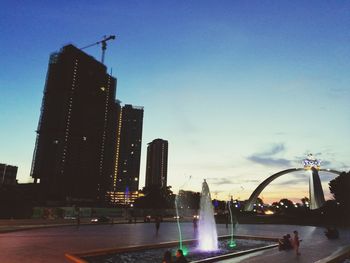 Fountain in city against sky