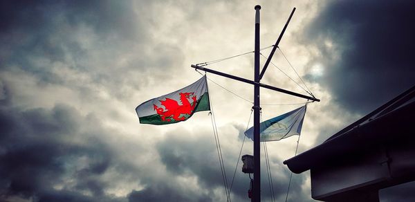 Low angle view of flag flags against sky