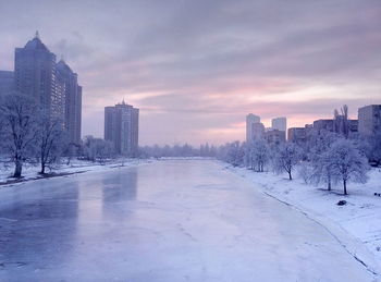 Scenic view of frozen river against dramatic sky during sunset