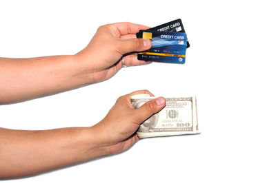 Close-up of hand holding paper over white background