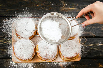 Cropped hand of person preparing food on table