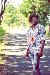 Full length of young man wearing sunglasses standing on road