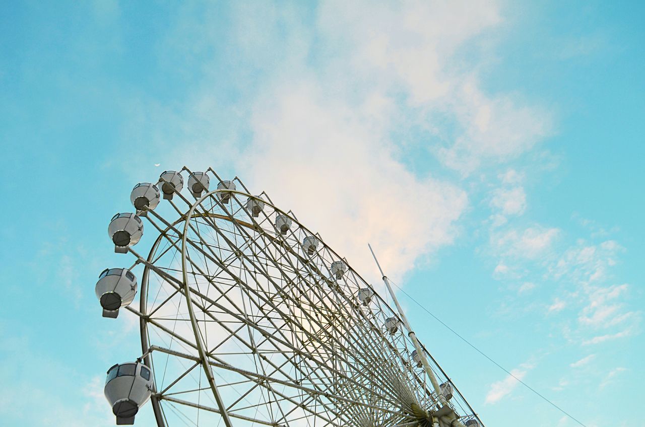low angle view, sky, ferris wheel, amusement park, built structure, amusement park ride, arts culture and entertainment, blue, architecture, building exterior, cloud - sky, outdoors, day, cloud, tall - high, no people, metal, tower, clear sky, street light