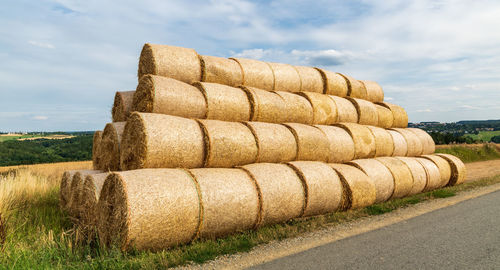 Hay bales on field against sky