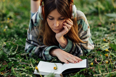 Full length of young woman sitting on field