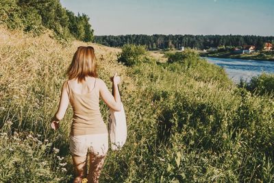 Rear view of woman walking in field