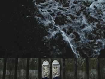 Low section of person standing in water