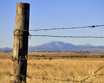 Fence on field against clear sky