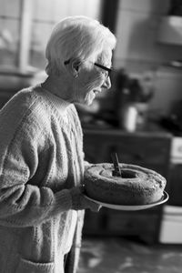 Side view of an old woman with a cake