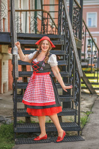 Portrait of young woman standing on staircase