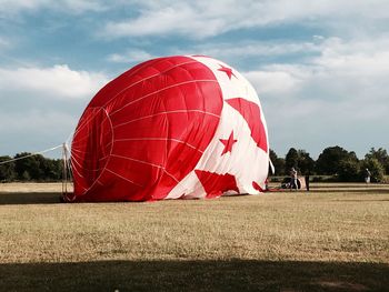 Hot air balloon on field against sky