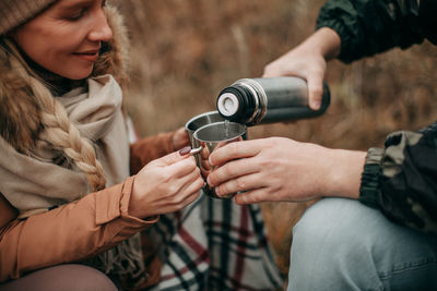 Midsection of man holding camera