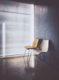 Empty chair on table against wall at home