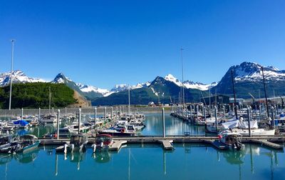 Boats moored in valdez harbor in front of mountains