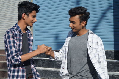 Side view of young couple standing against wall